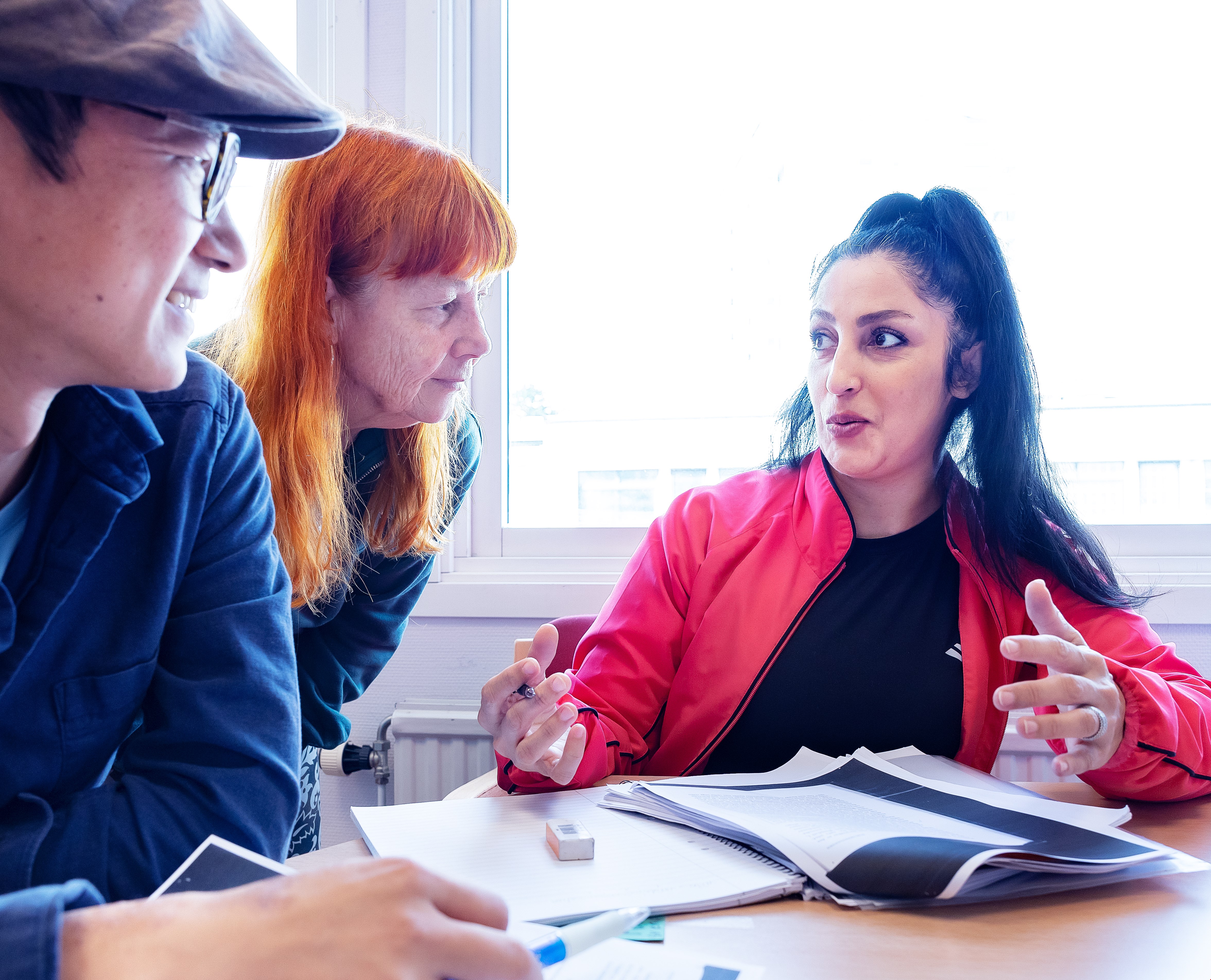 Två deltagare och en lärare runt ett bord